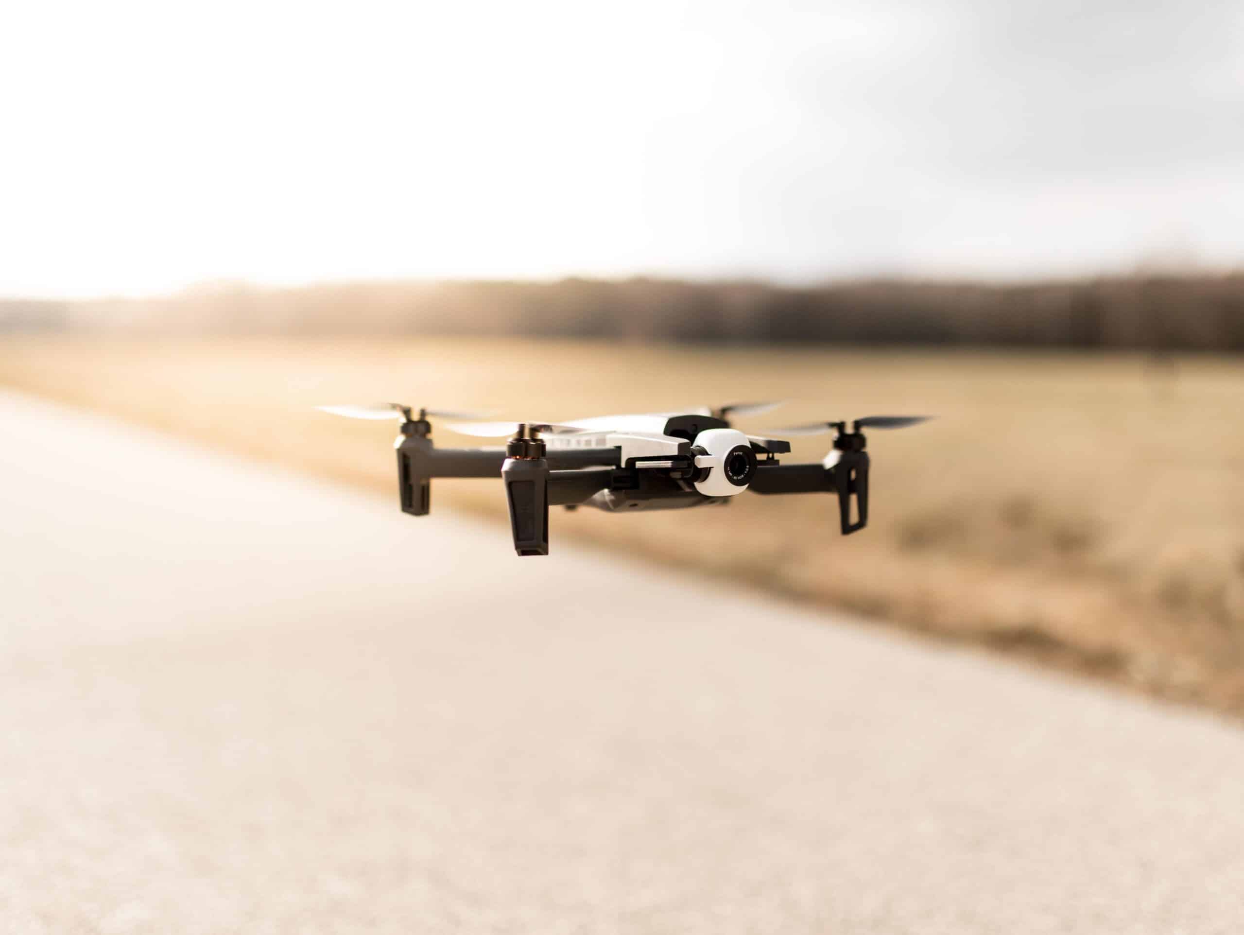 A black quadcopter drone over a cloudy sky